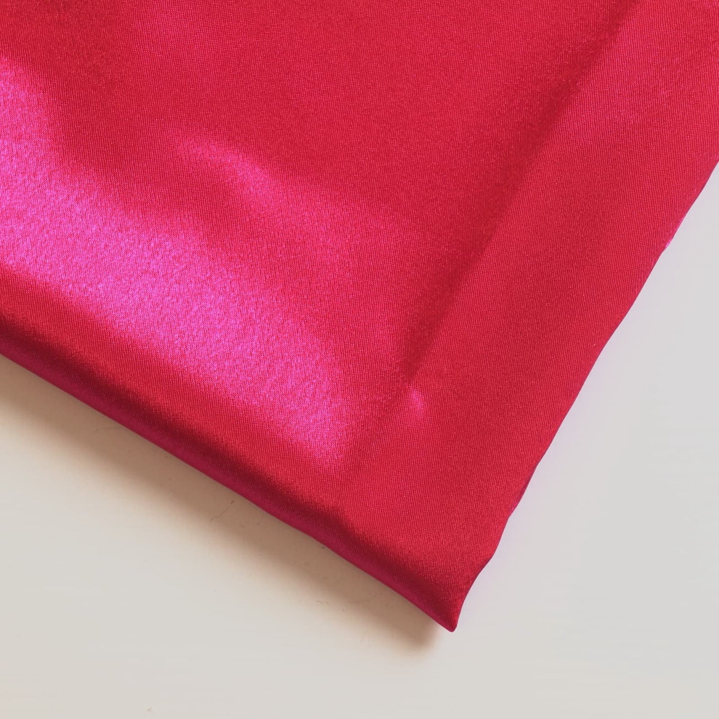 Bright pink polyester satin fabric close up