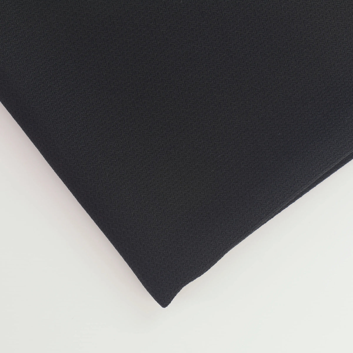 black-basket-weave-textured-polyester-suiting-fabric – close-up of colour, pattern and texture