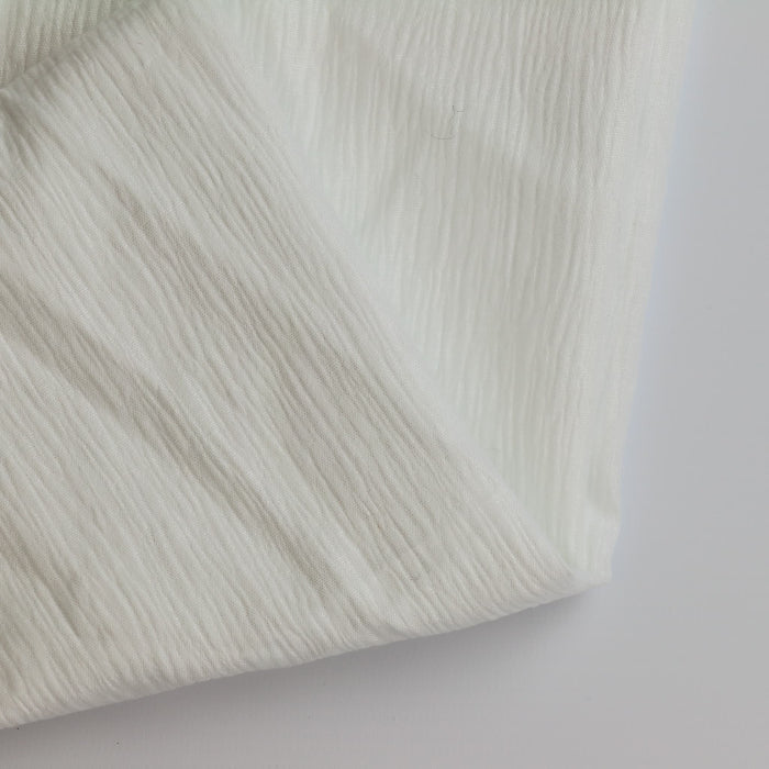White poly-cotton crinkle fabric remnant folded showing detail
