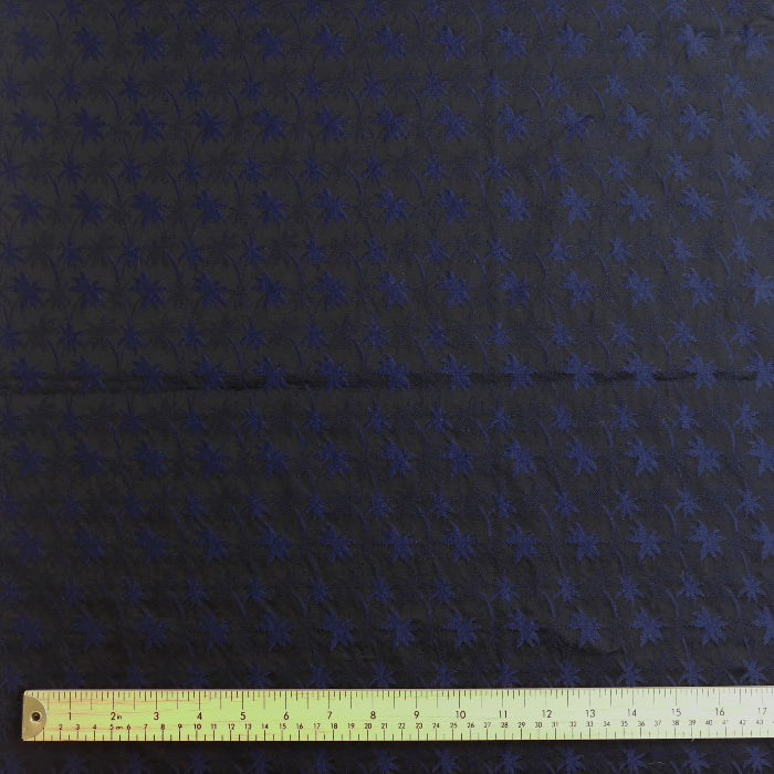 Navy and black palm print jacquard fabric laid flat