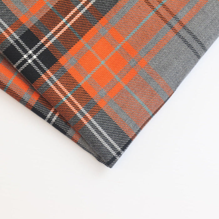 Close-up of folded orange and grey tartan fabric weave