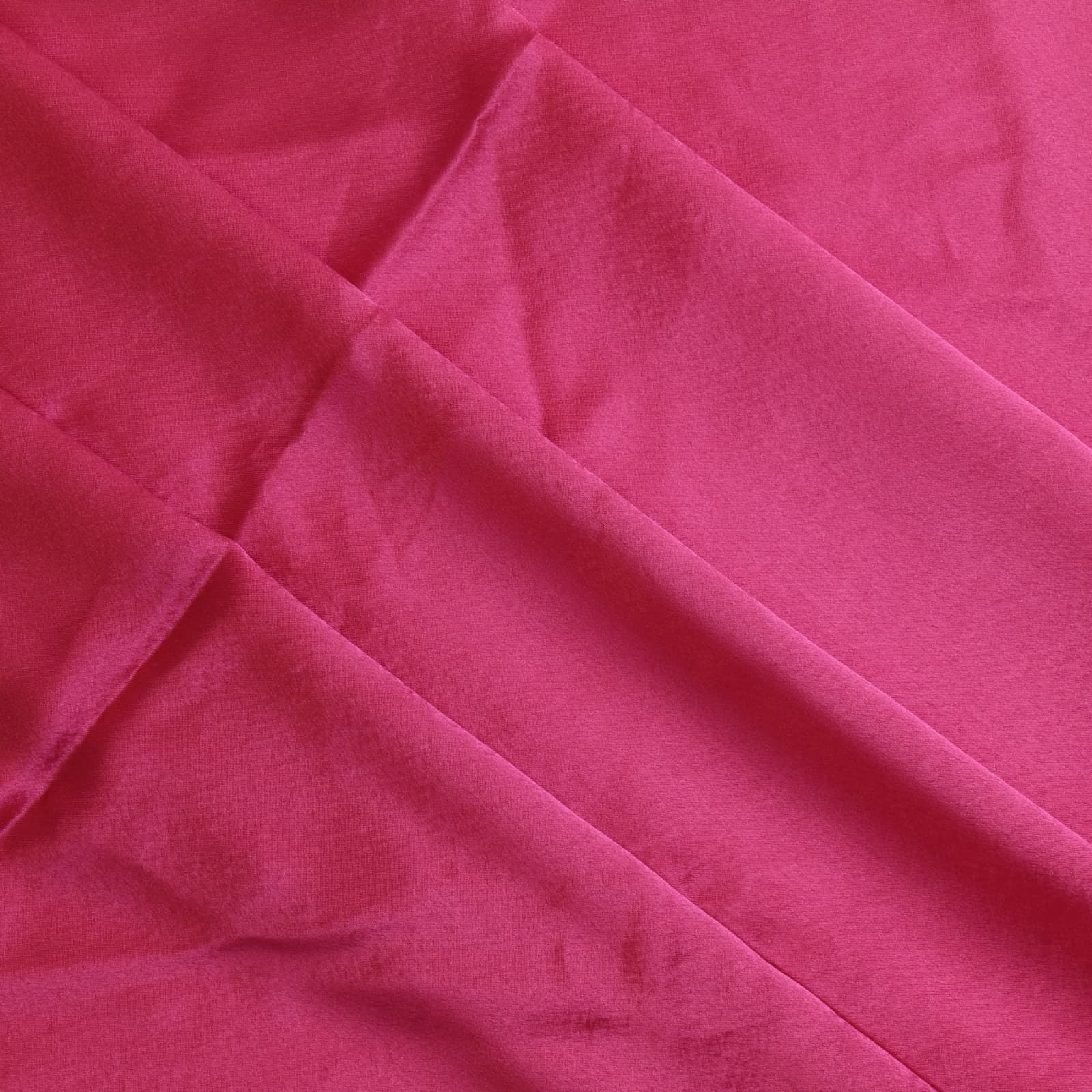 Bright pink polyester satin fabric gently folded