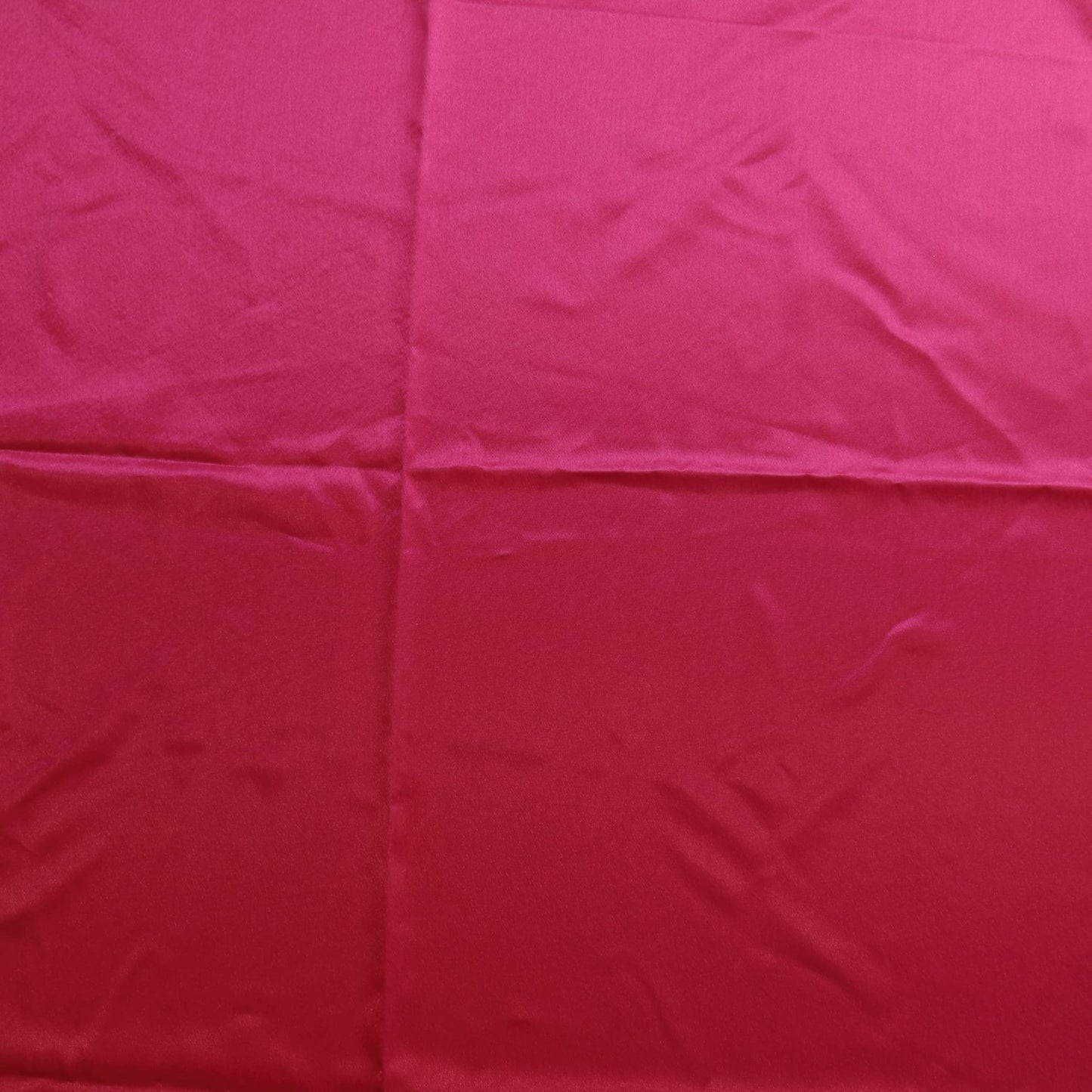 Bright pink polyester satin fabric laid flat