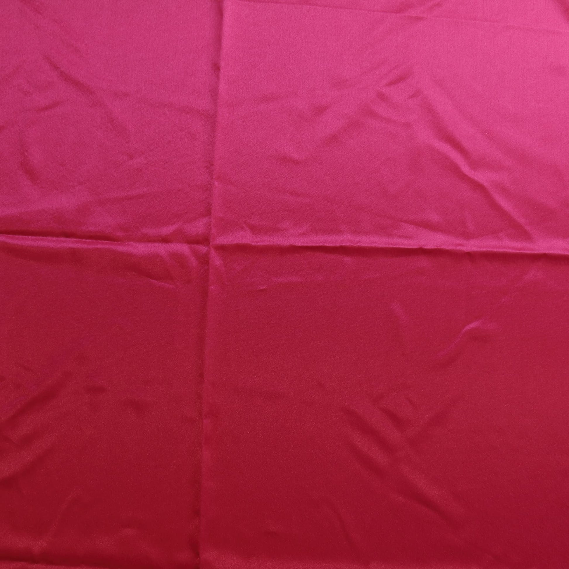 Bright pink polyester satin fabric laid flat