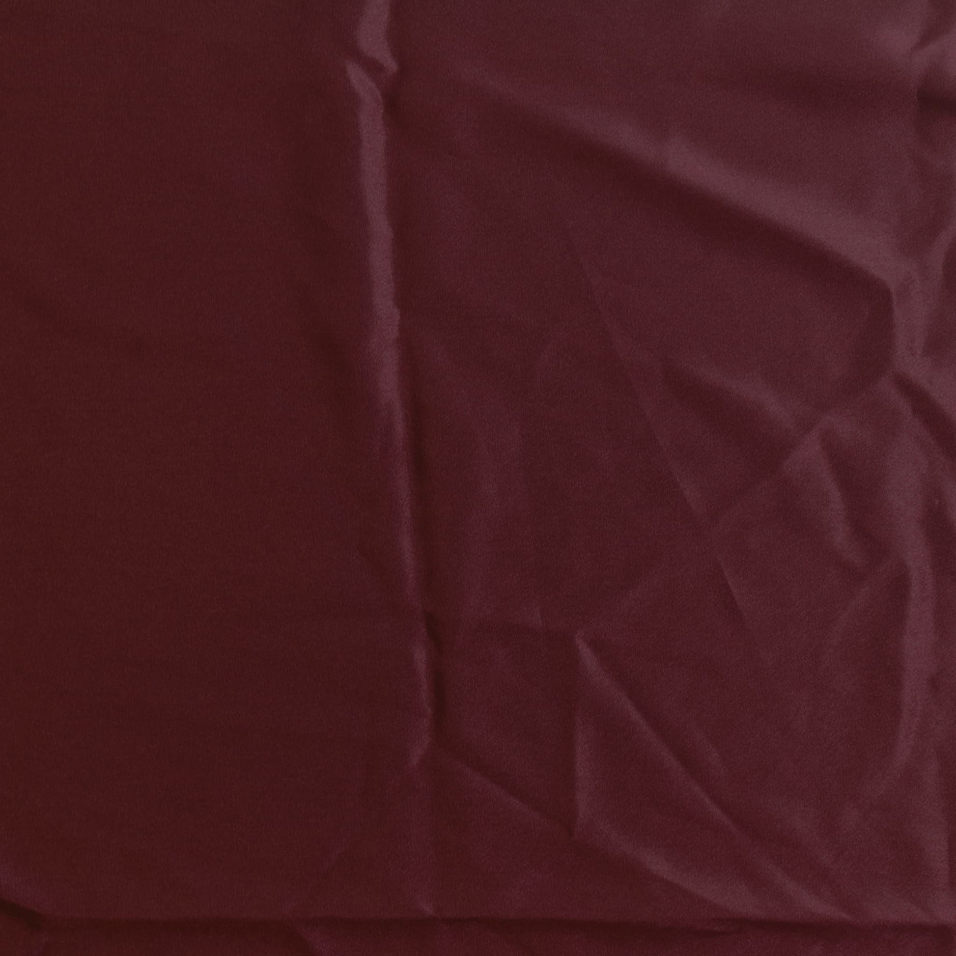 Wine red polyester satin fabric laid flat