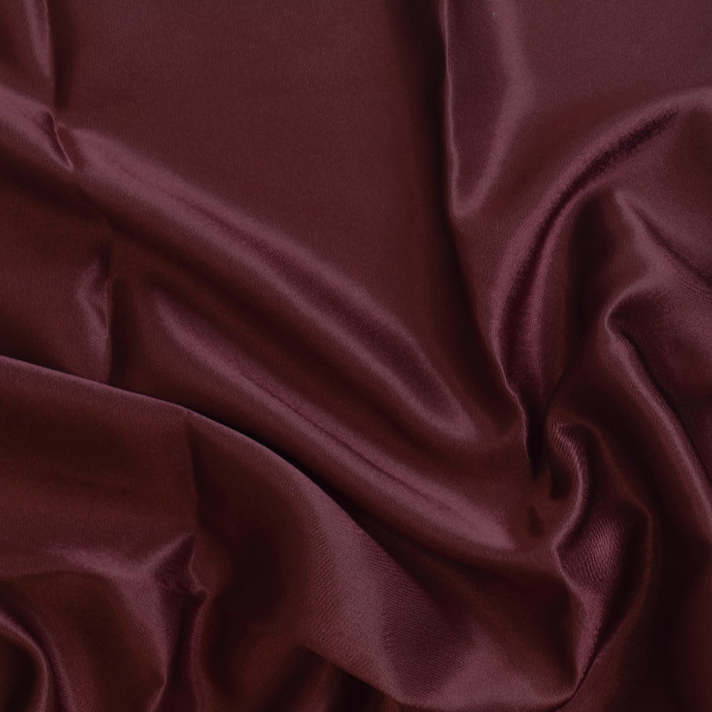 Wine red polyester satin fabric showing drape and sheen