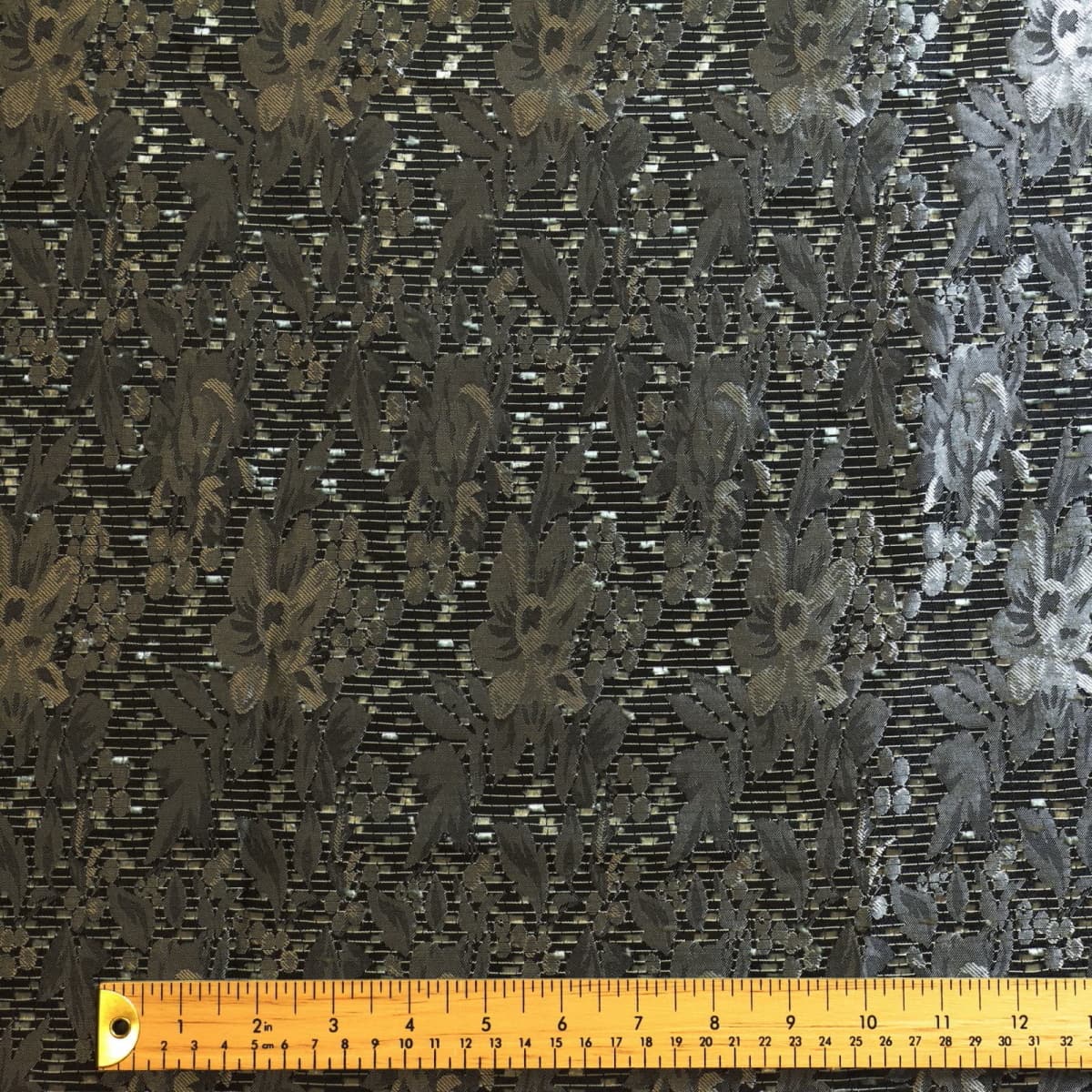 Green multicolour spotted dressmaking fabric laid flat