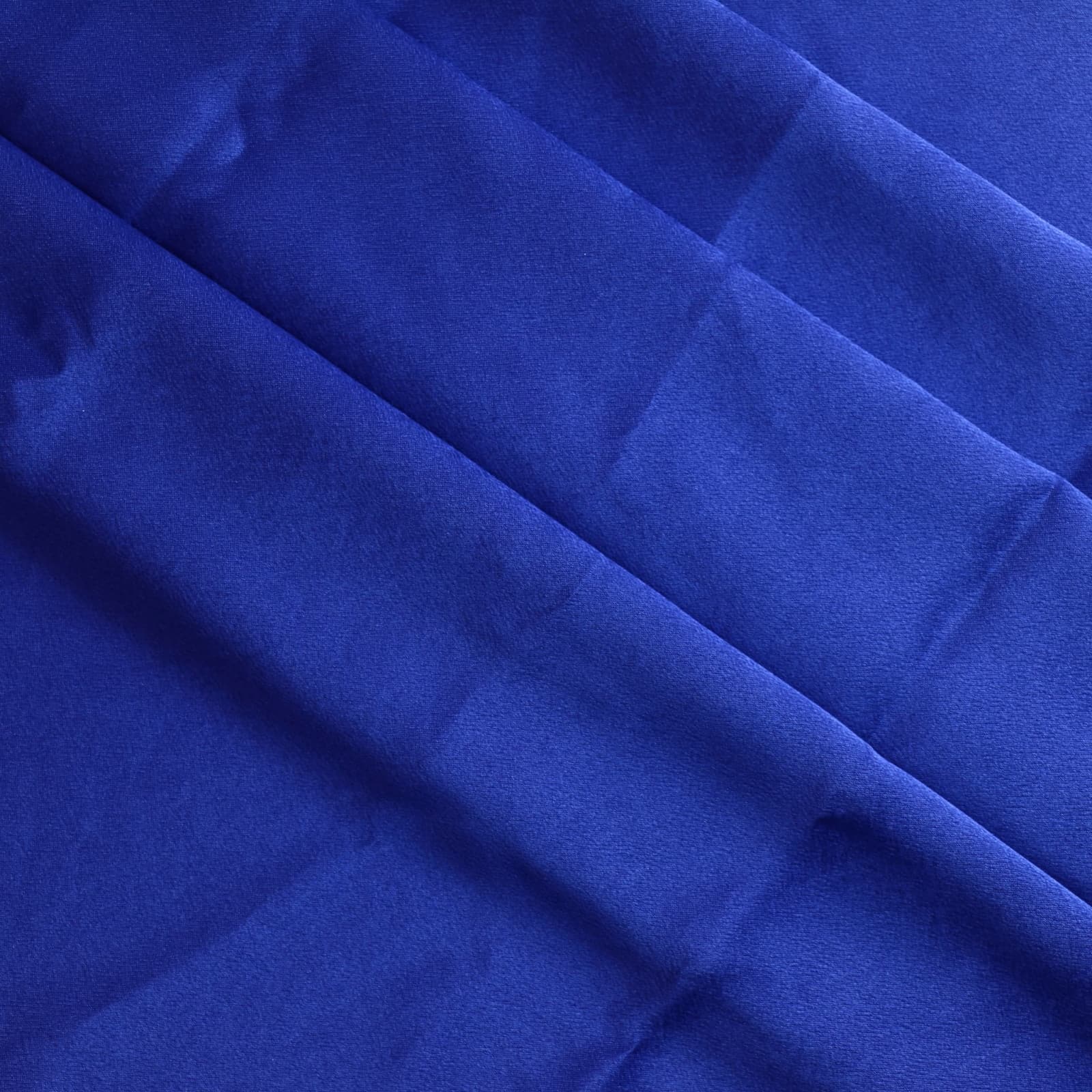 Bright blue polyester satin fabric gently folded
