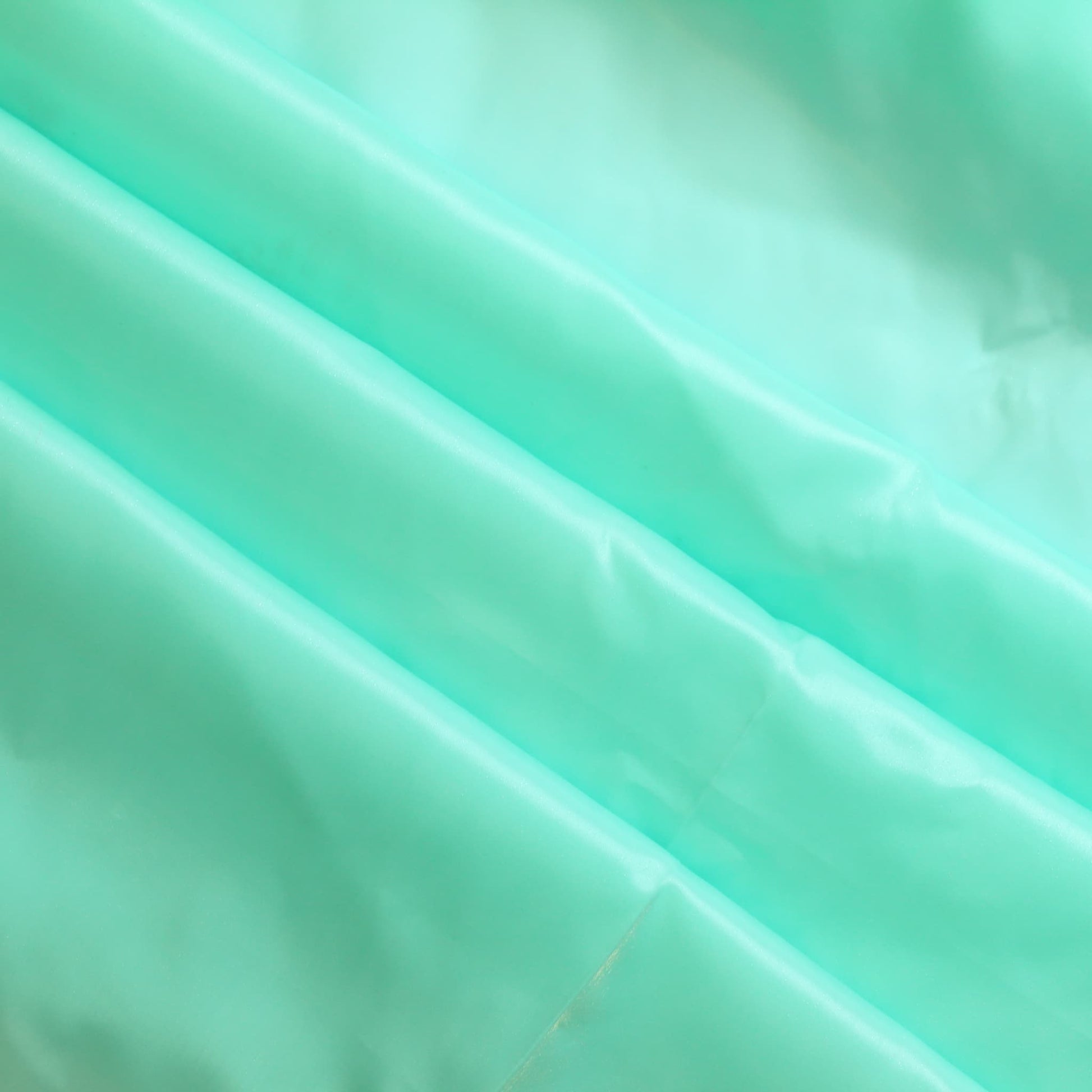 Turquoise nylon satin fabric gently folded