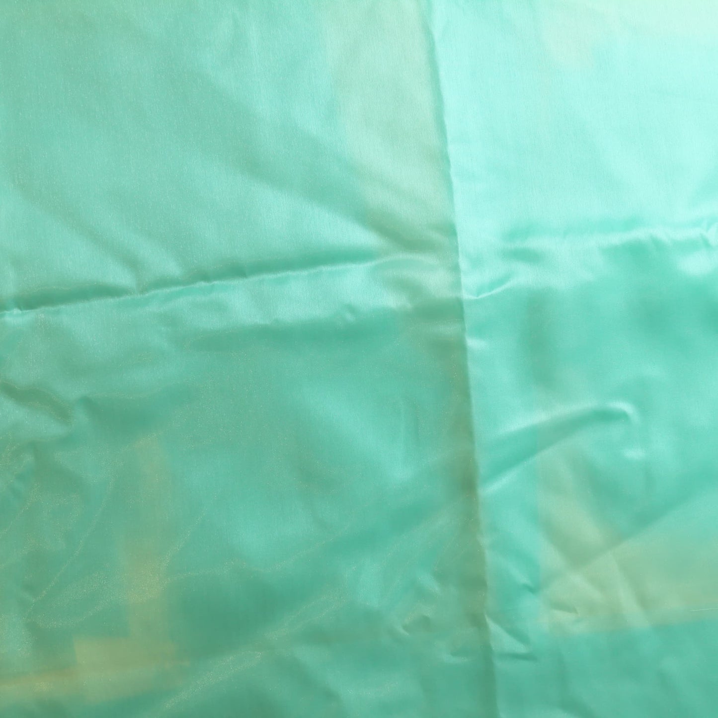Turquoise nylon satin fabric showing sun damage