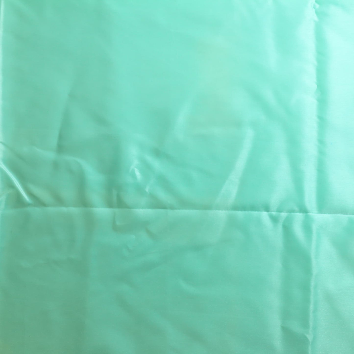 Turquoise nylon satin fabric laid flat