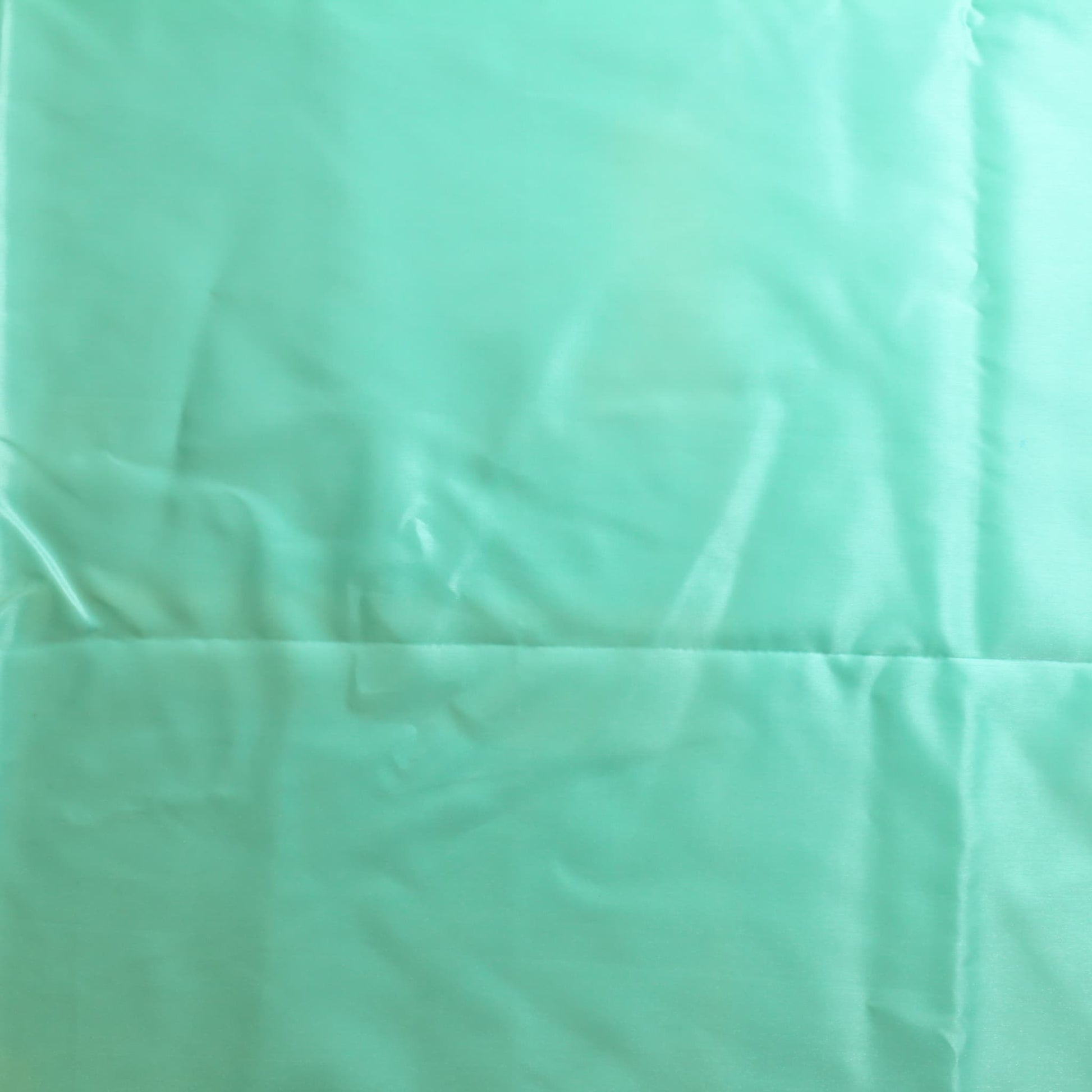 Turquoise nylon satin fabric laid flat