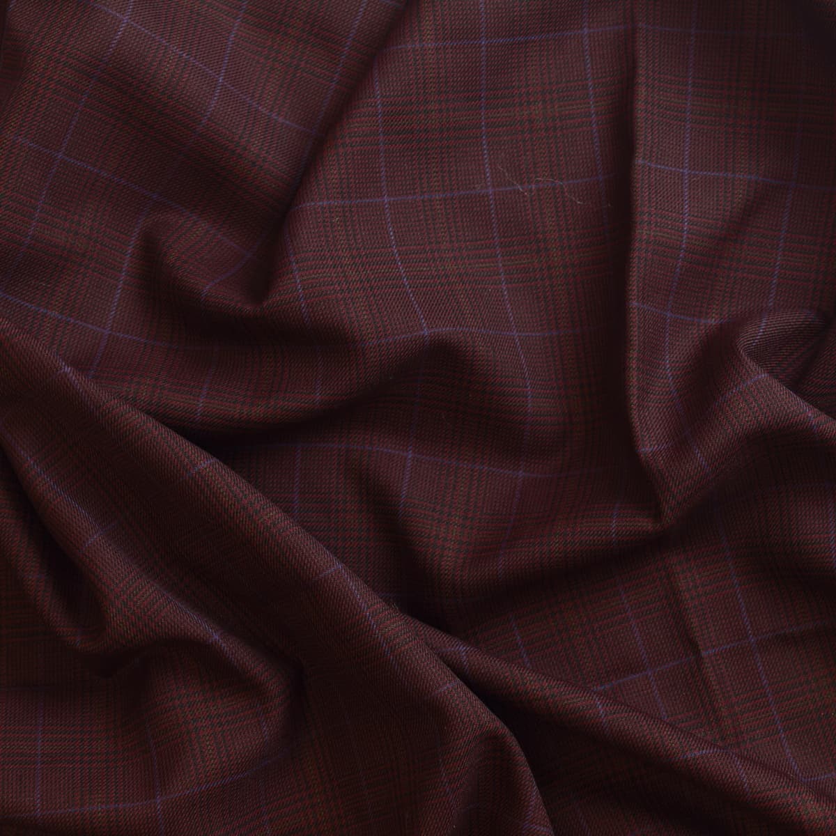 Dark red viscose polyester tartan suiting fabric showing drape