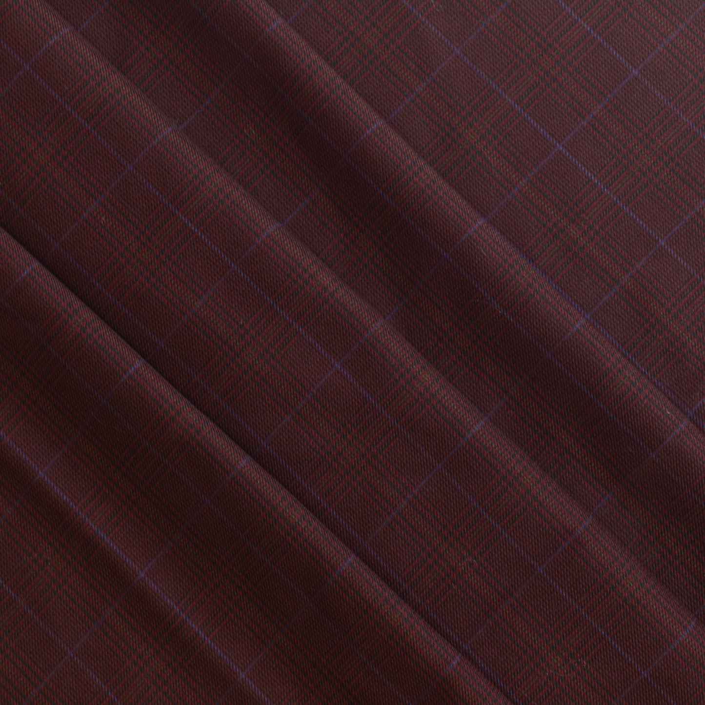 Dark red viscose polyester tartan suiting fabric gently folded