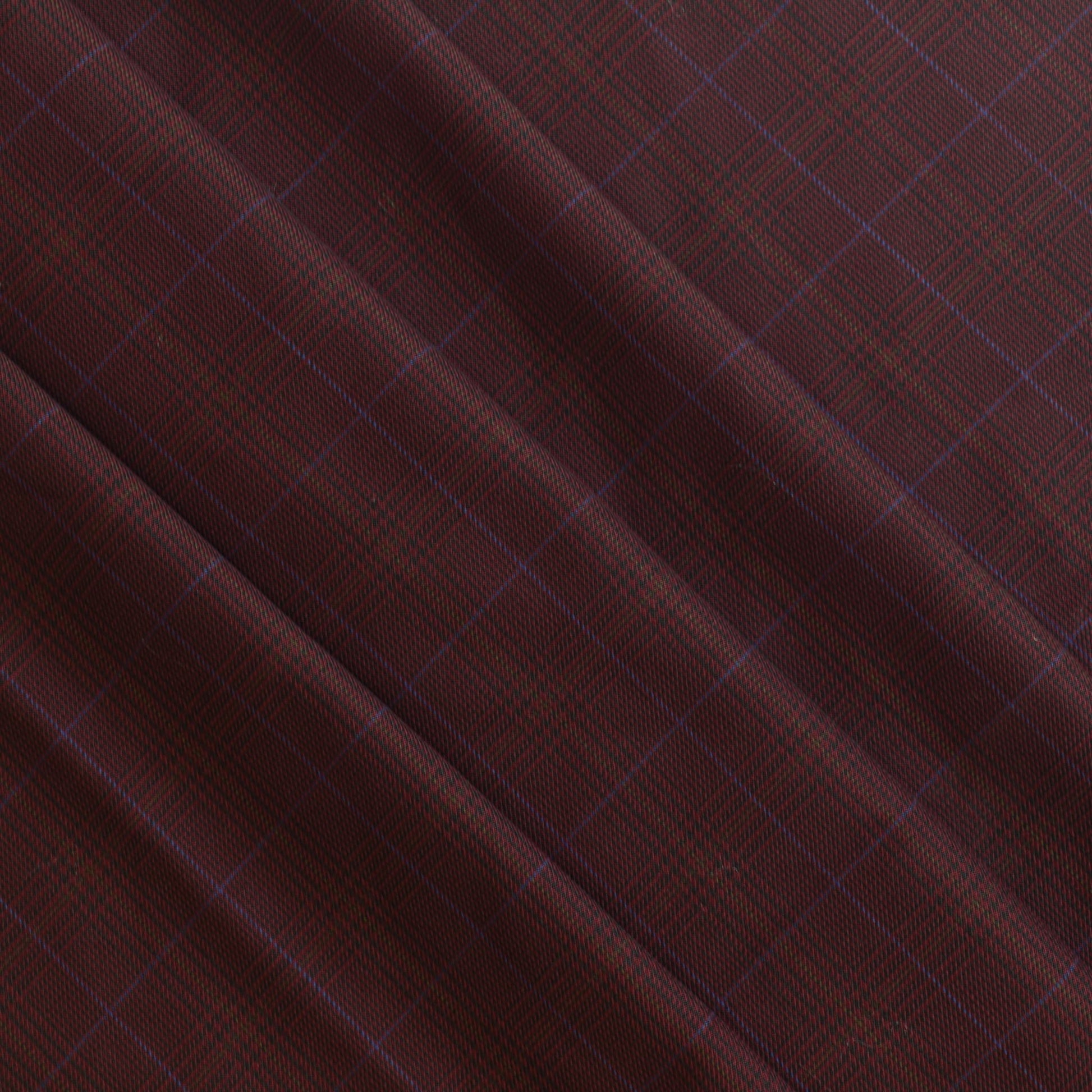 Dark red viscose polyester tartan suiting fabric gently folded