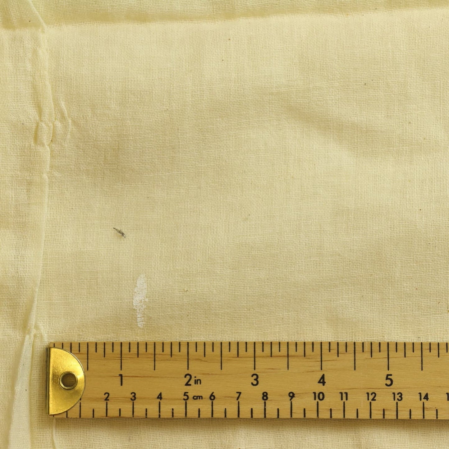 Cream butter muslin sewing fabric close up showing mark