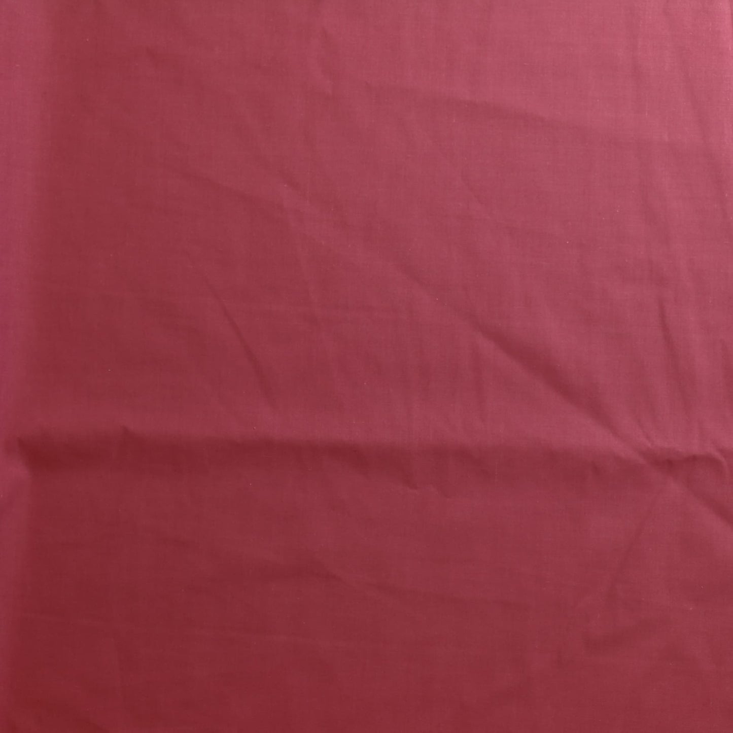 Dusky pink poly-cotton sewing fabric laid flat