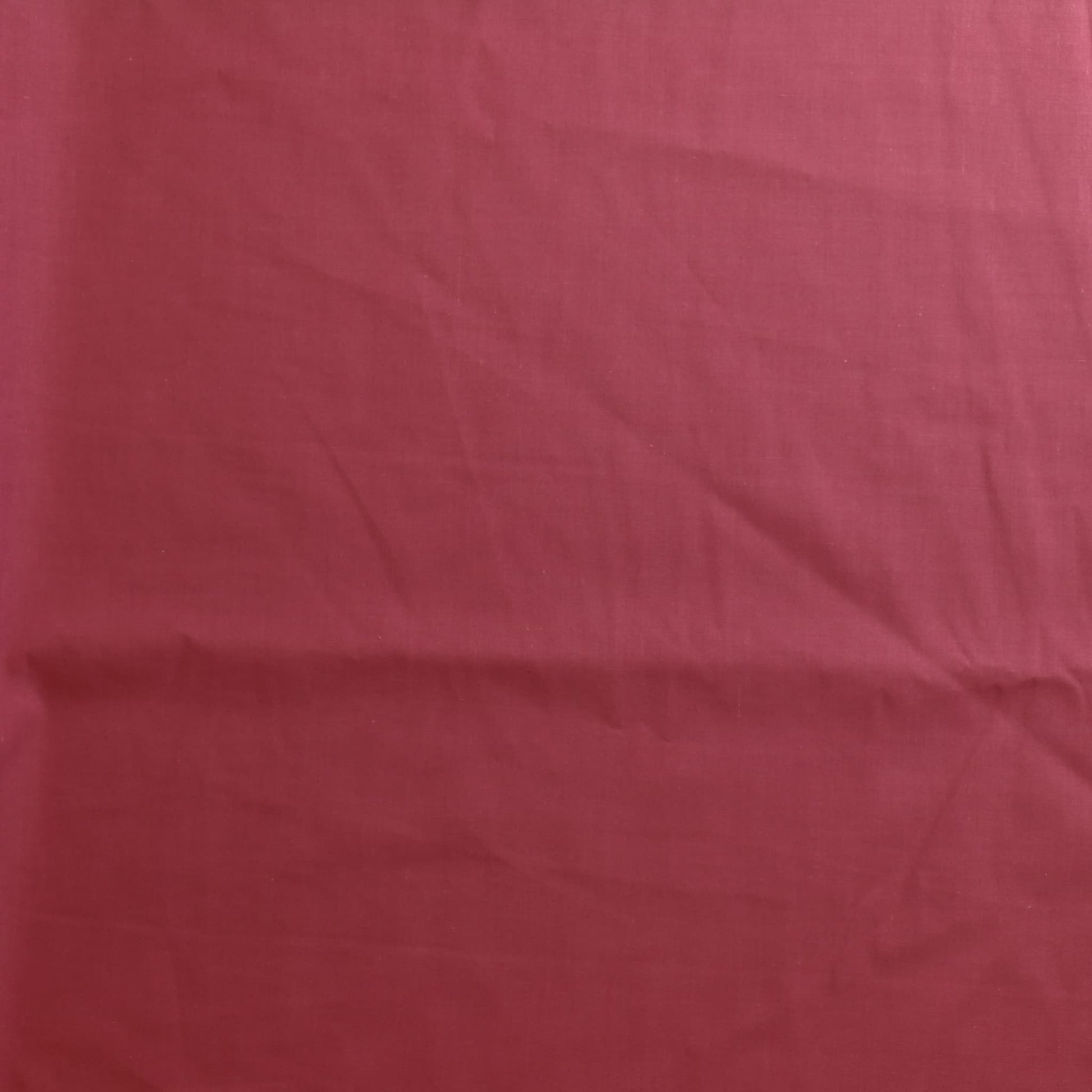 Dusky pink poly-cotton sewing fabric laid flat