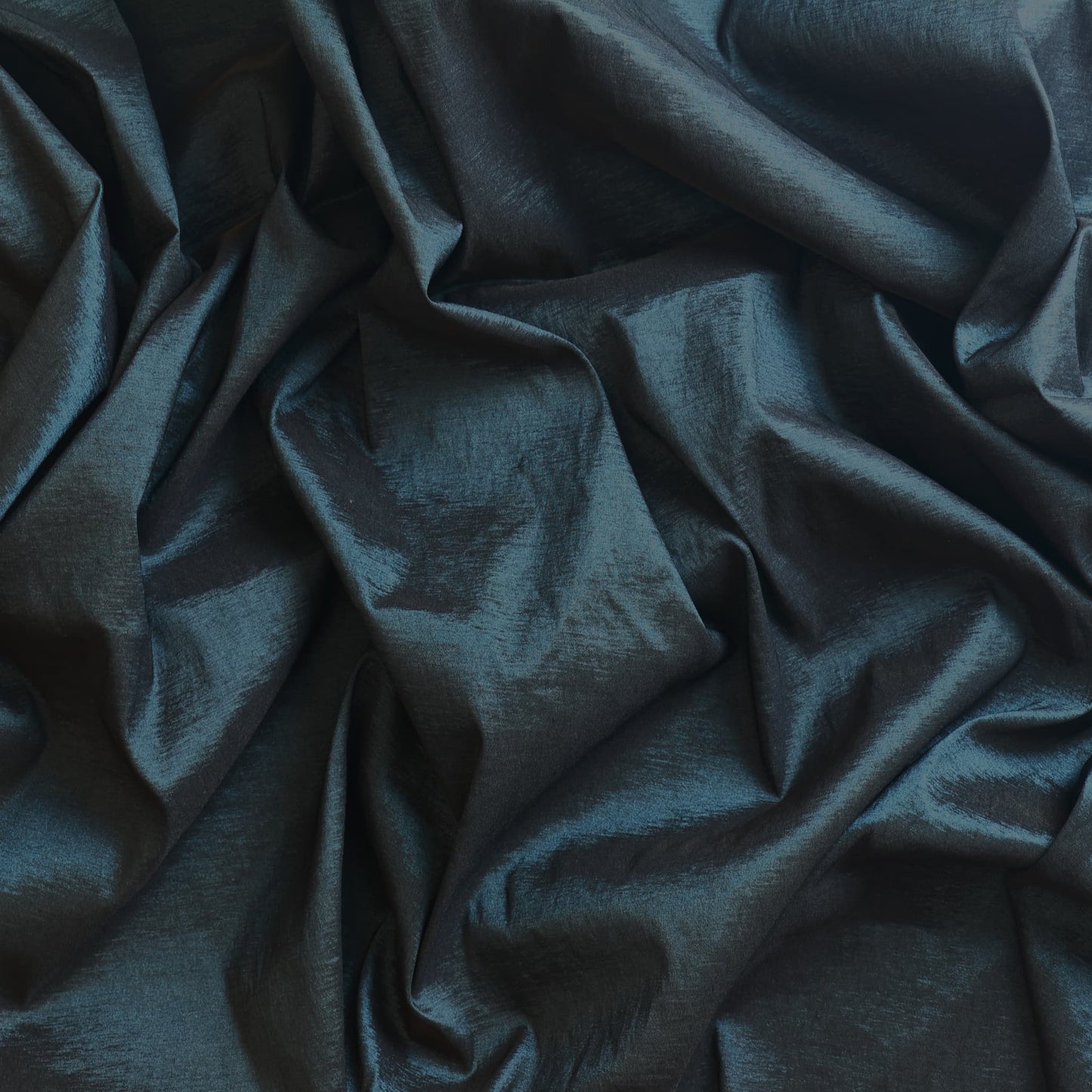 Dark teal stretch dupioni sewing fabric showing drape