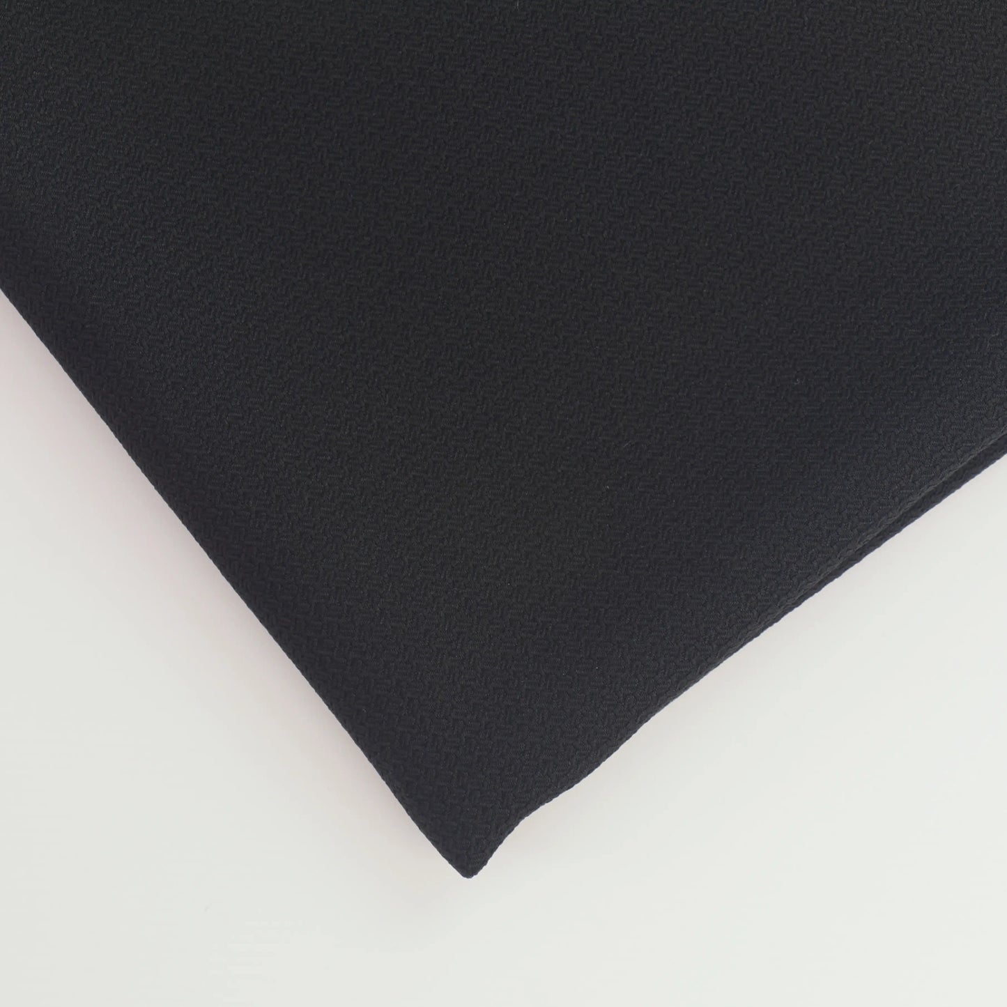 black-basket-weave-textured-polyester-suiting-fabric – close-up of colour, pattern and texture