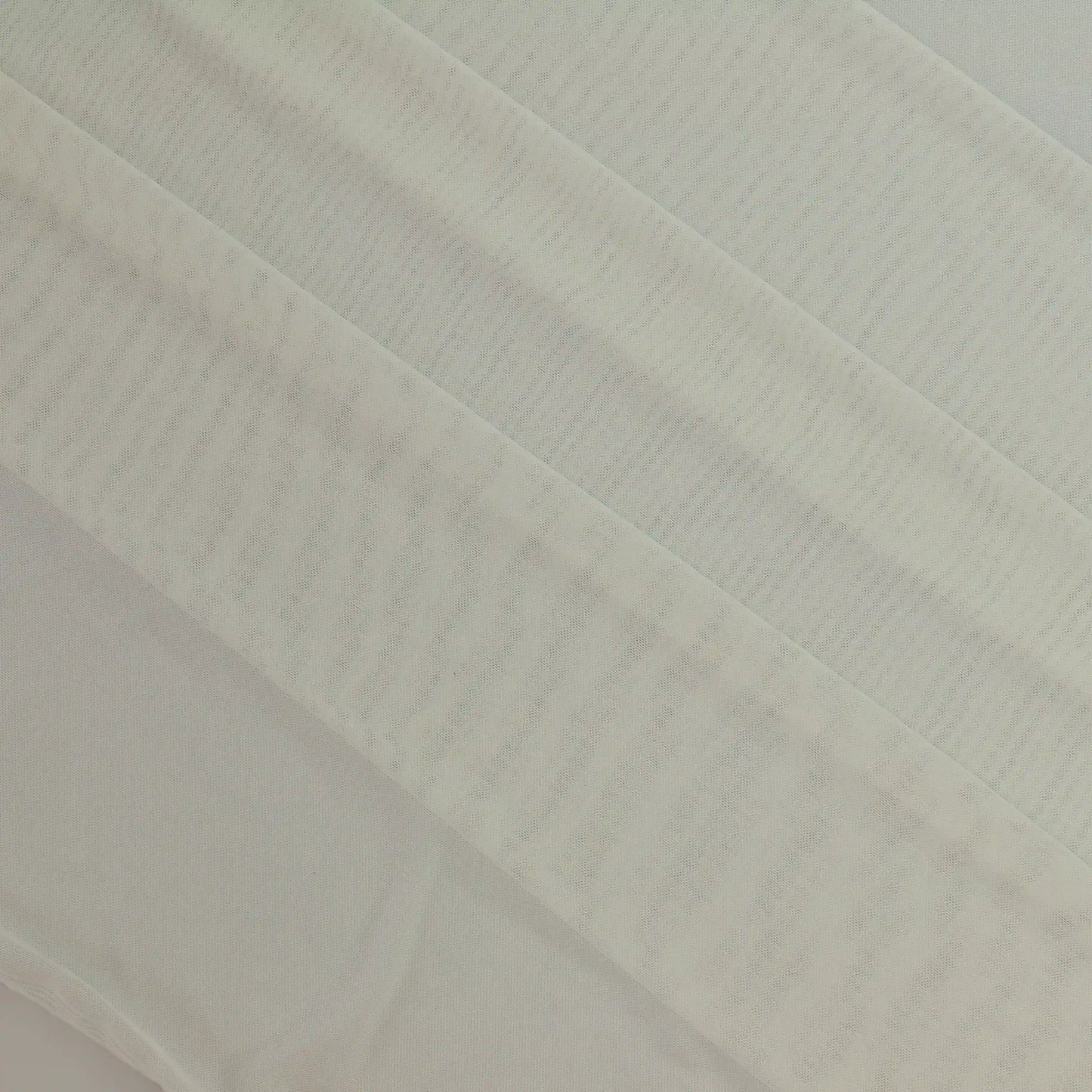 white-sheer-stretch-mesh-fabric – product laid flat showing its colour and pattern