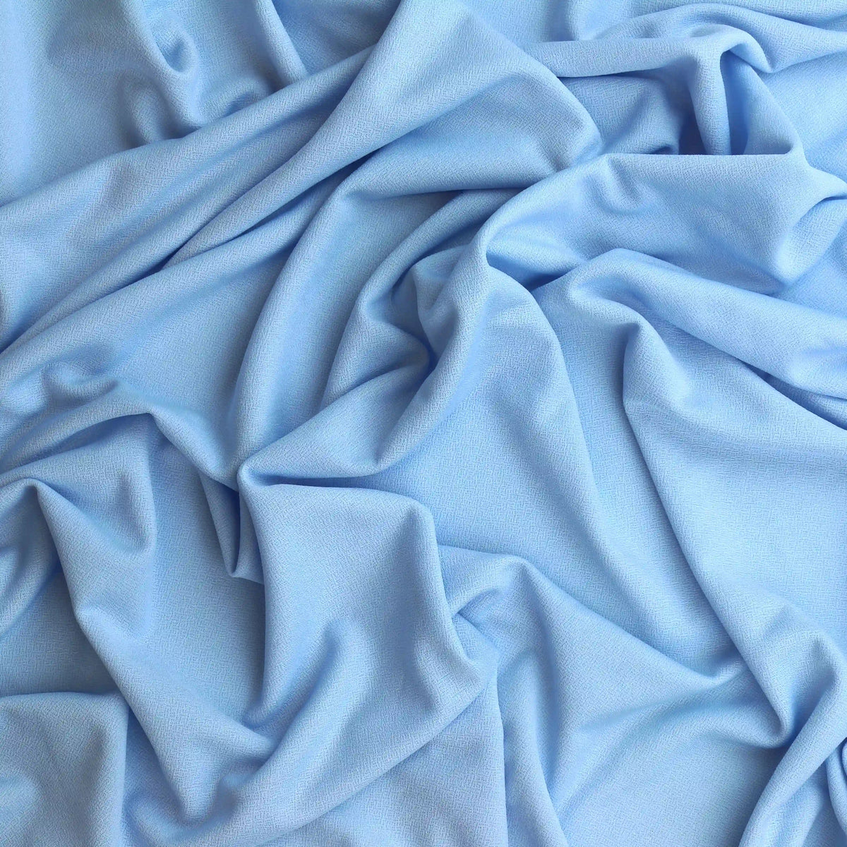 pale-blue-polyester-jersey-fabric – product gently folded showing its colour and texture