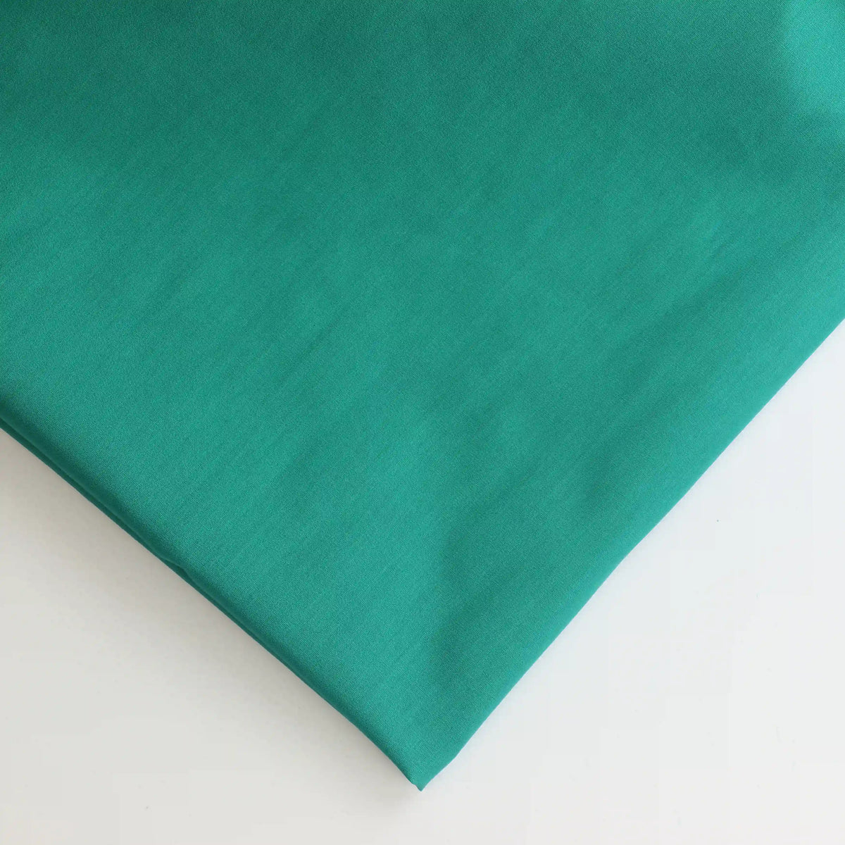 green-lightweight-cotton-lawn-fabric – close-up of colour, pattern and texture