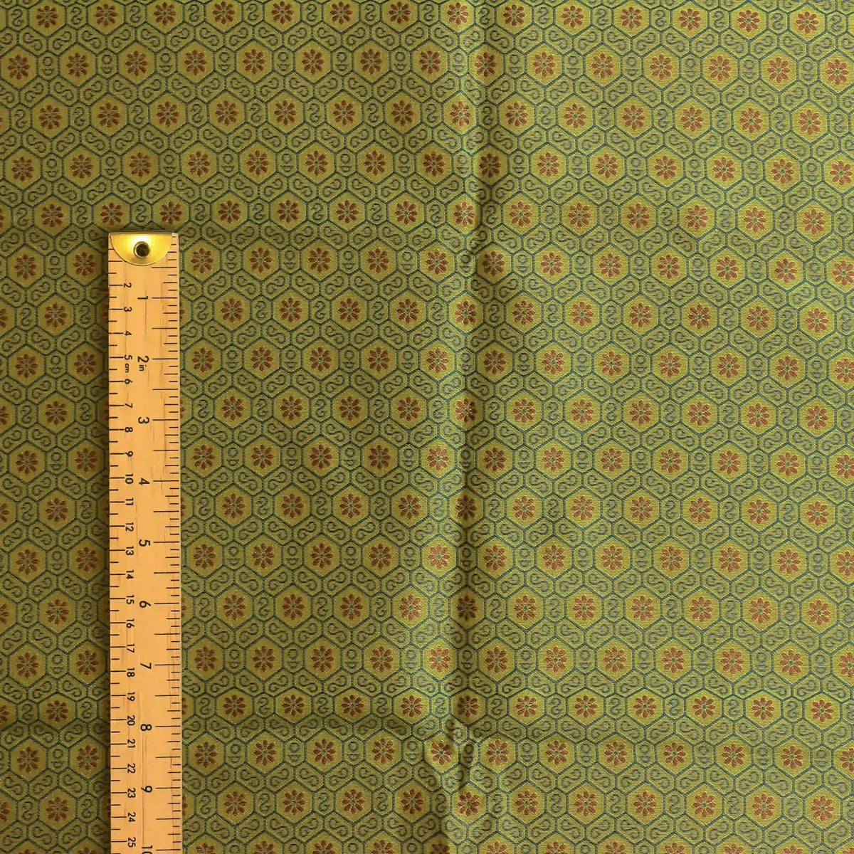 green-gold-geometric-brocade-fabric – product gently folded showing its colour, texture and drape