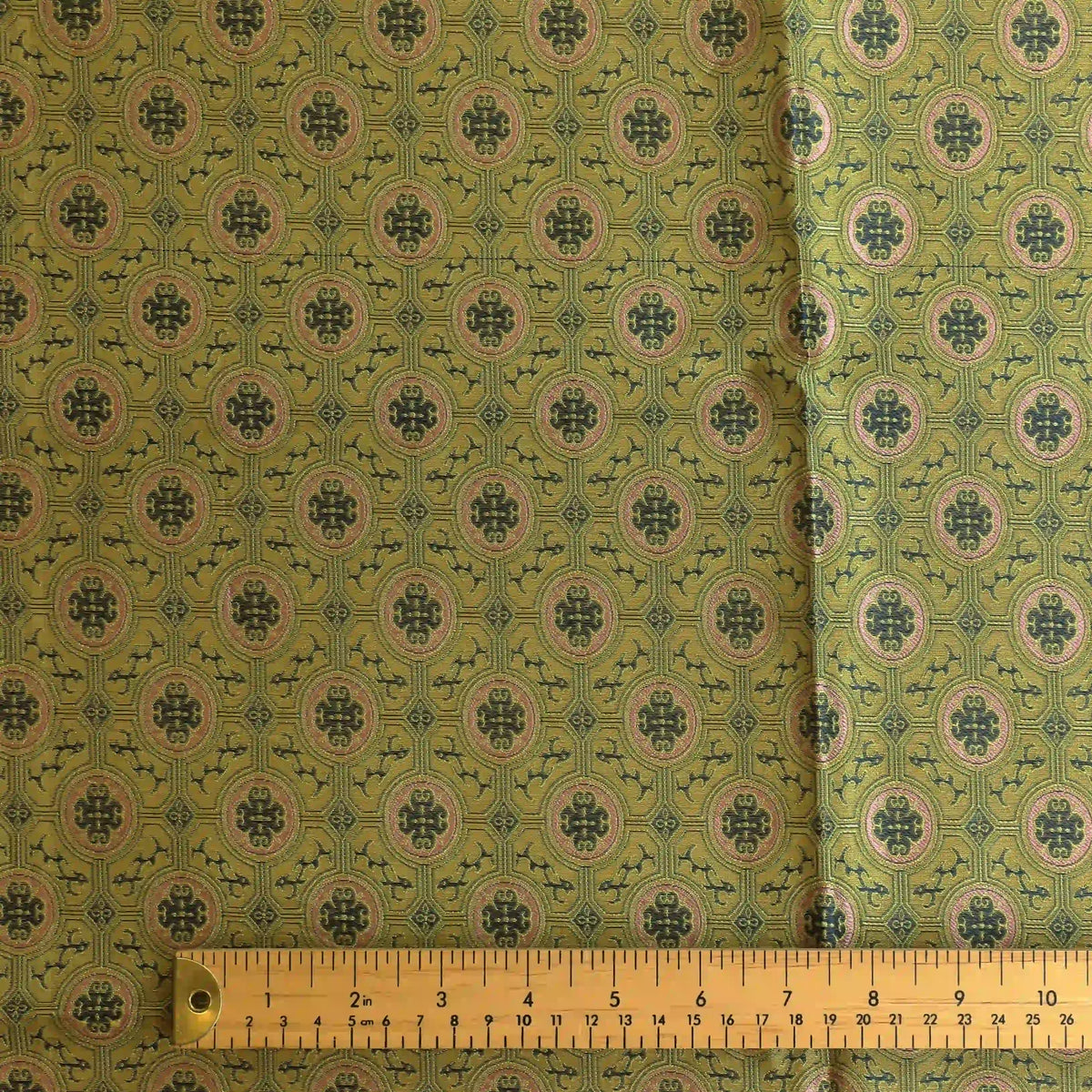 gold,-green-&-pink-geometric-brocade-fabric – product gently folded showing its colour, texture and drape
