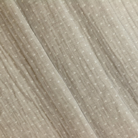 Close-up of a textured beige fabric with subtle patterns