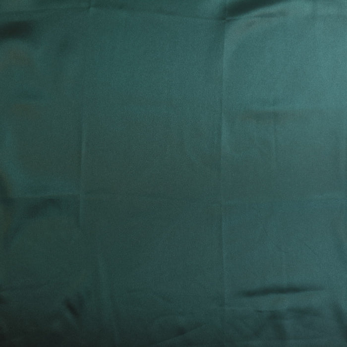 Deep green polyester satin fabric laid flat