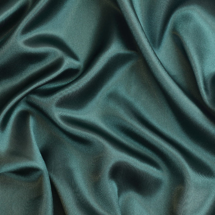 Deep green polyester satin fabric showing texture and drape