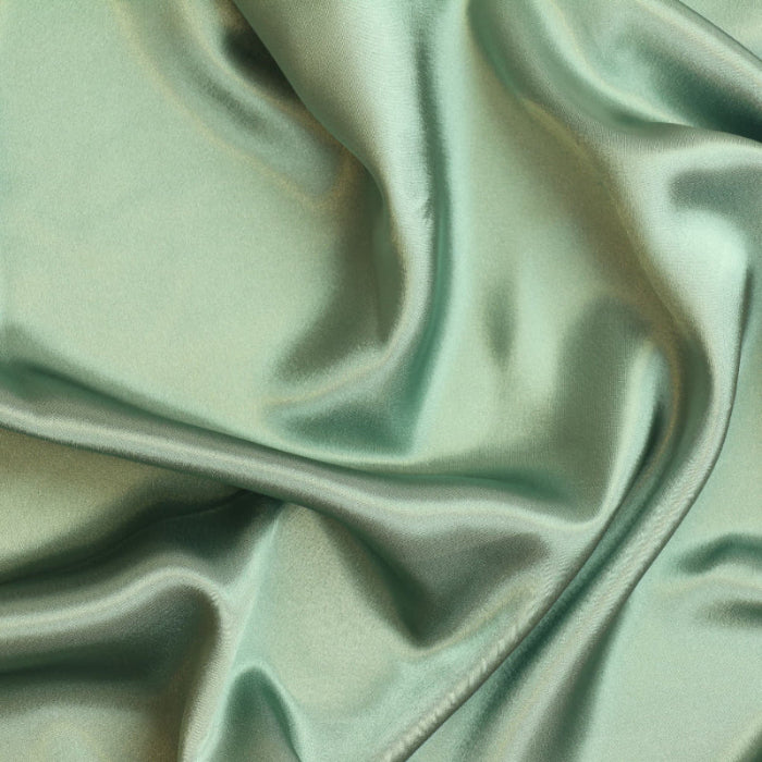 Sage green charmeuse satin fabric showing drape