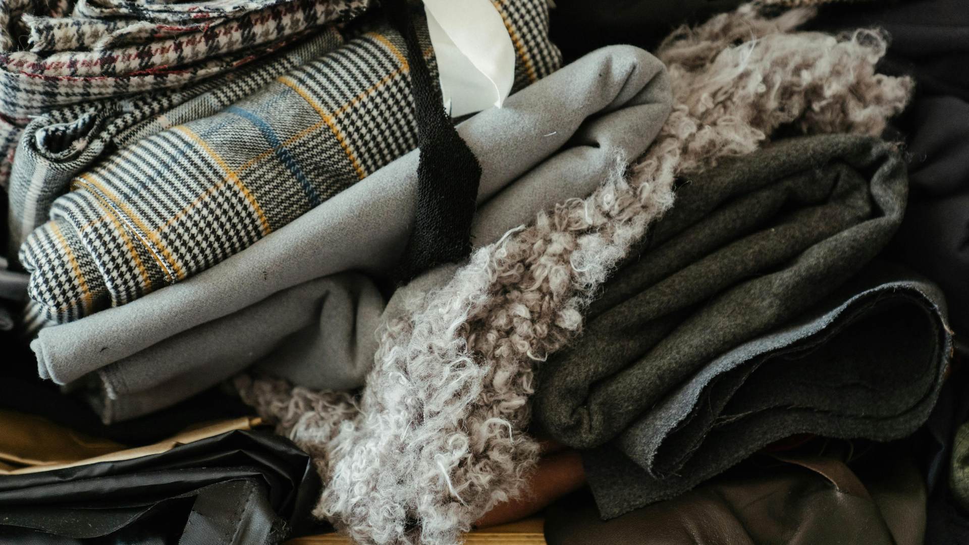 Stack of folded clothing including plaid and textured fabrics